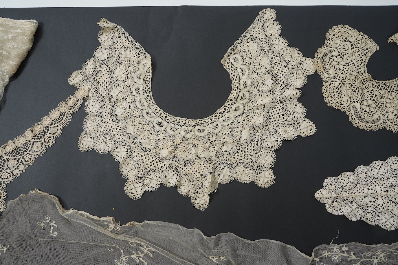 A needle run embroidered net skirt, a similar Bertha, five large silk Maltese bobbin lace collars and trimming, a length of Venetian style lace, mittens etc. Condition - good